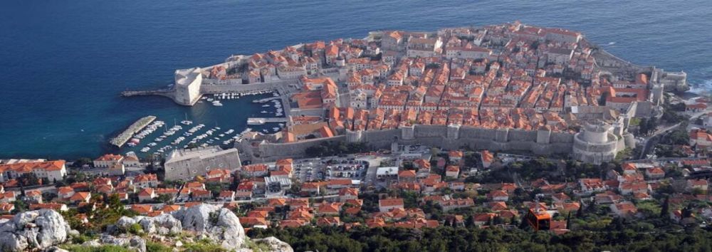 Widok z góry na starówkę w mieście Dubrovnik, wpisaną na listę UNESCO. Wyraźnie widoczne potężne, dobrze zachowane mury miejskie.